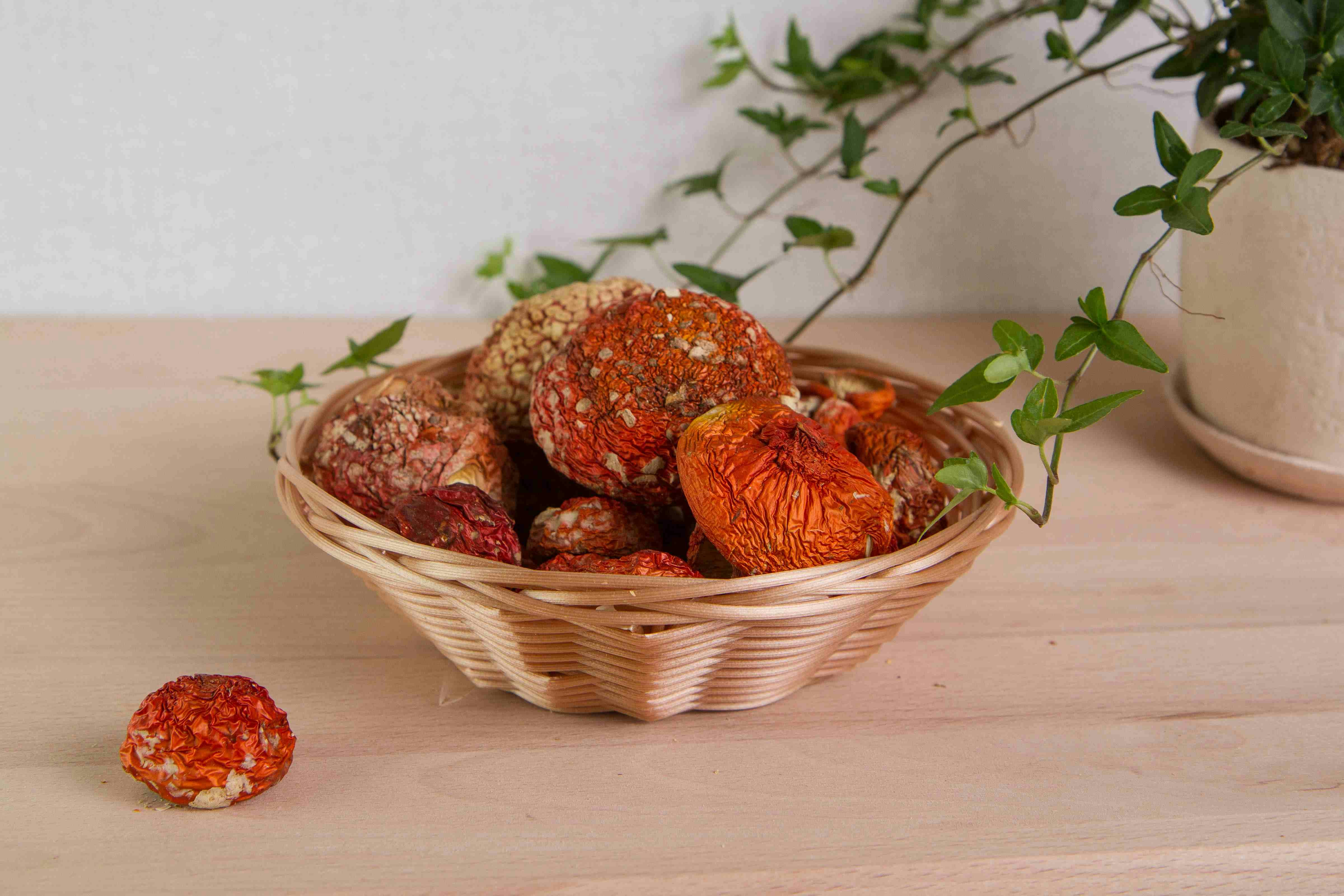 a basket of dried fruit sitting on a table next to a potted plant