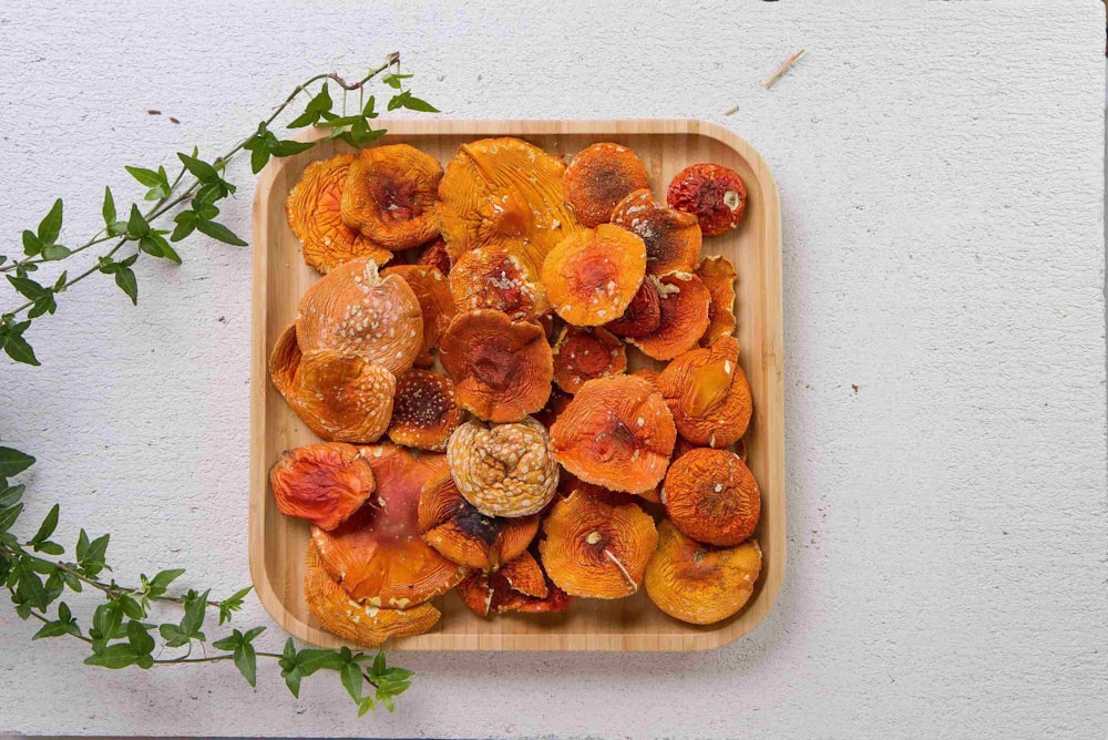 a wooden tray filled with dried fruit on top of a table
