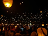 Evening wedding scene with glowing lanterns and guests enjoying the celebration.