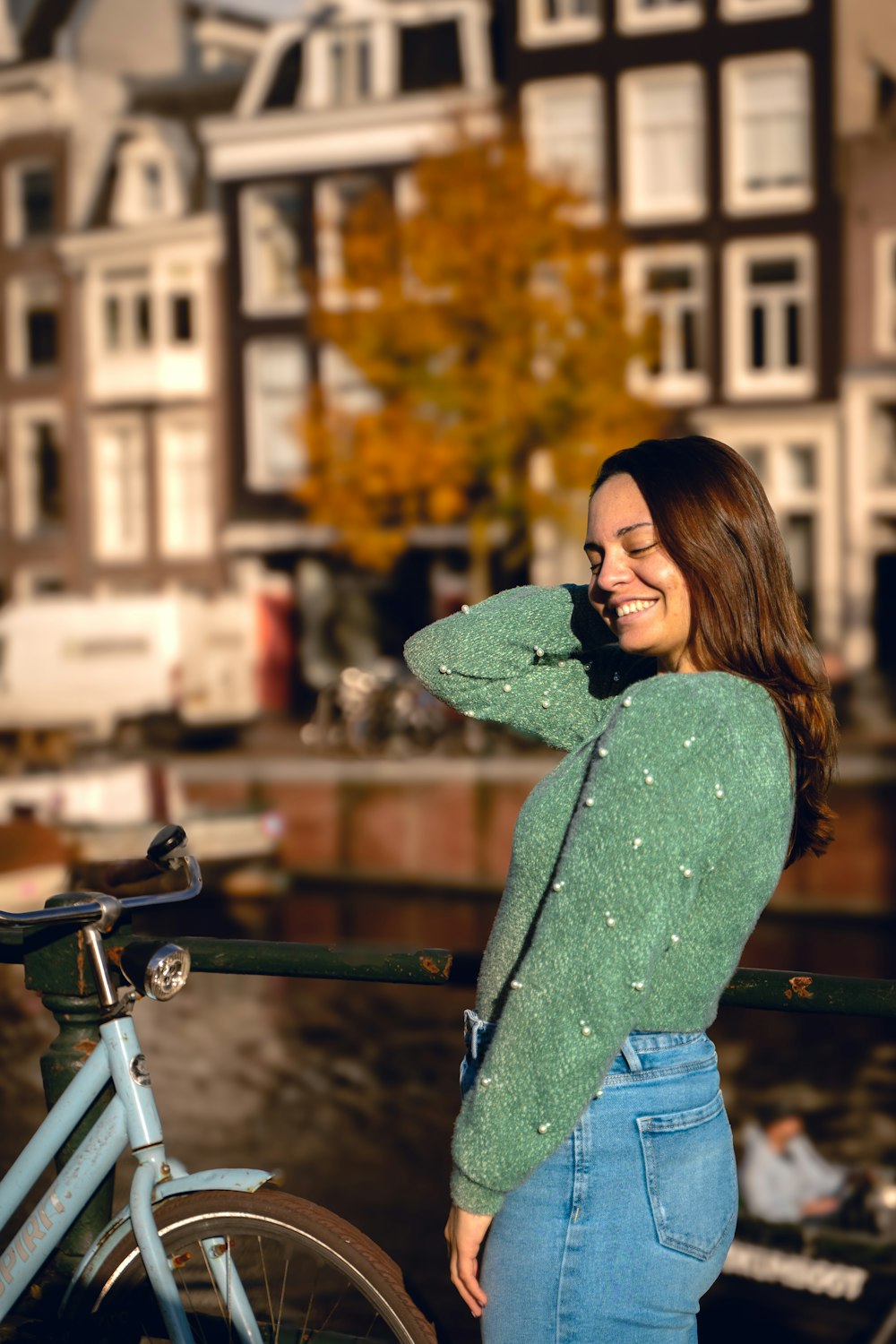 a woman standing next to a bike talking on a cell phone