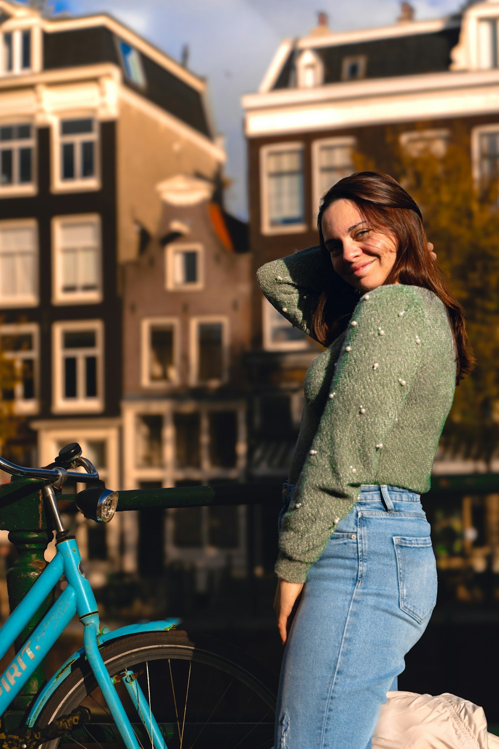 a woman standing next to a blue bike