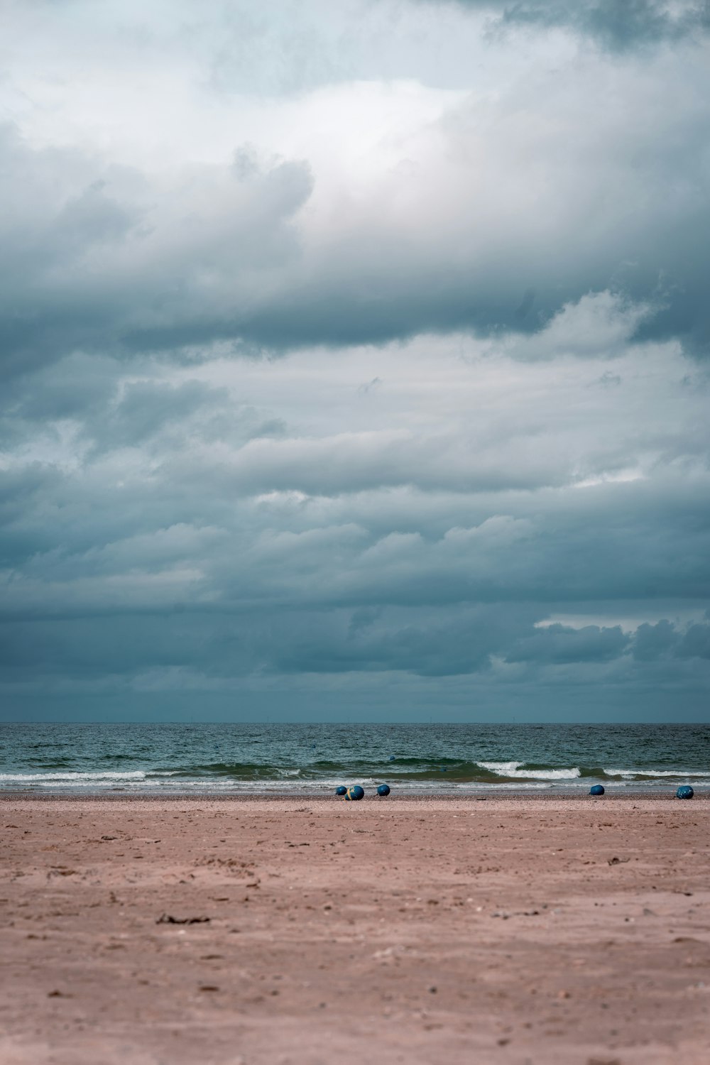 a couple of people on a beach with a surfboard