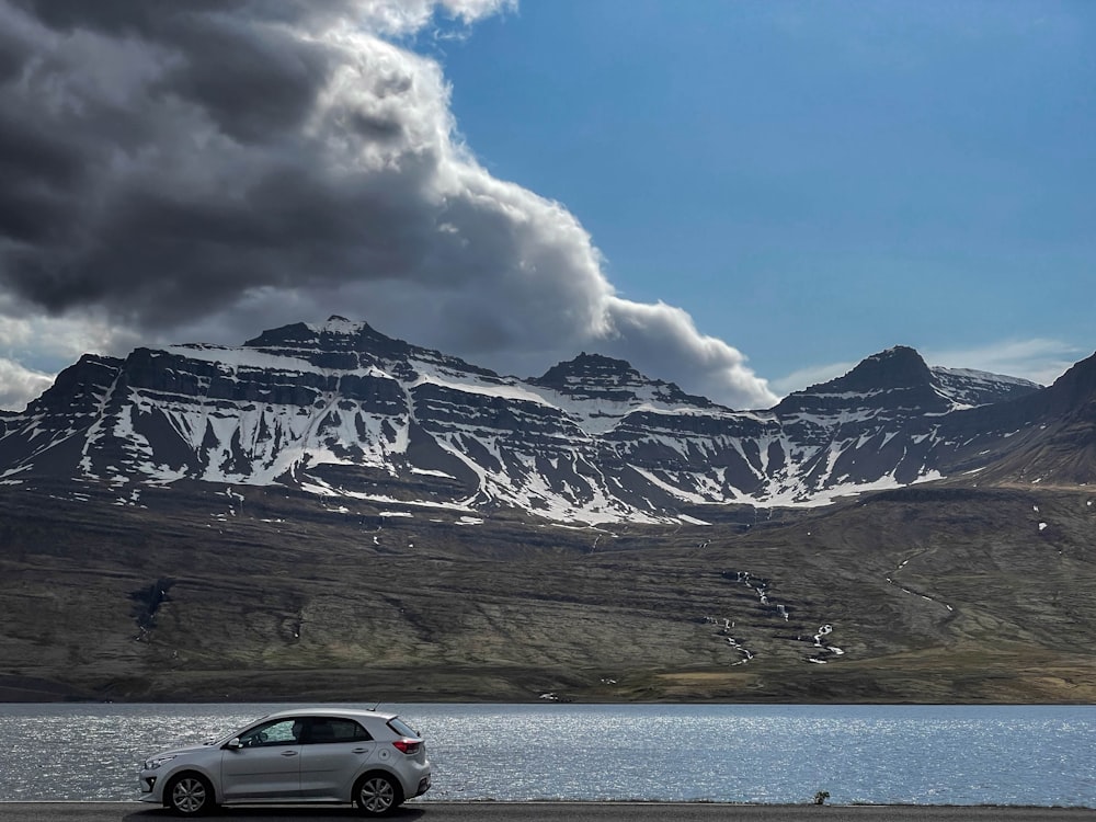 a car driving on a road next to a lake