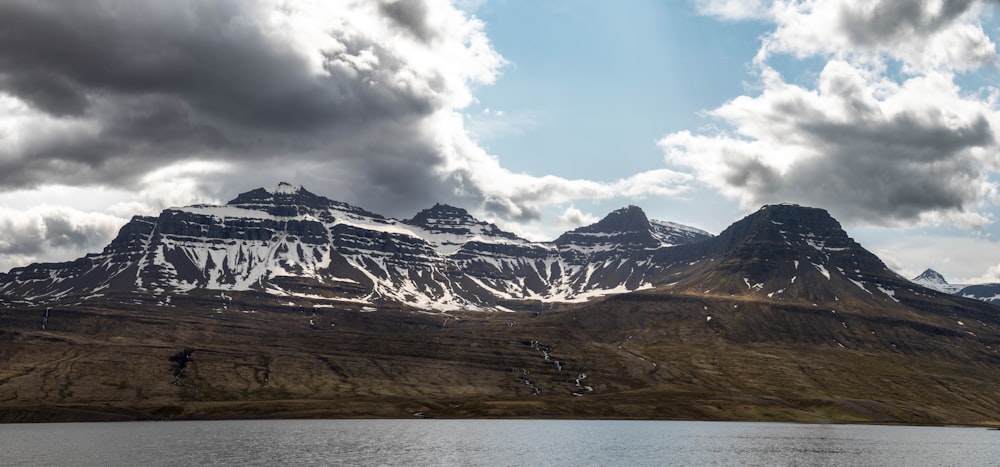 the mountains are covered in snow and clouds