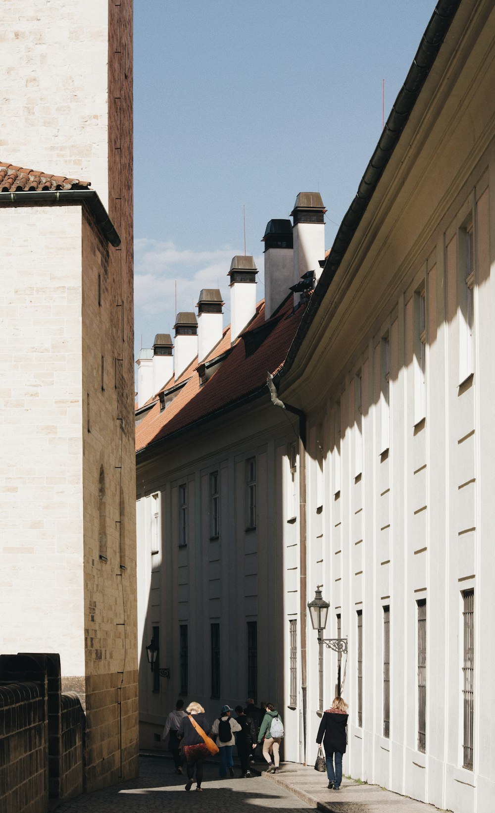 a group of people walking down a street next to tall buildings