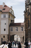 A scenic European street with students walking and chatting, framed by historic architecture.