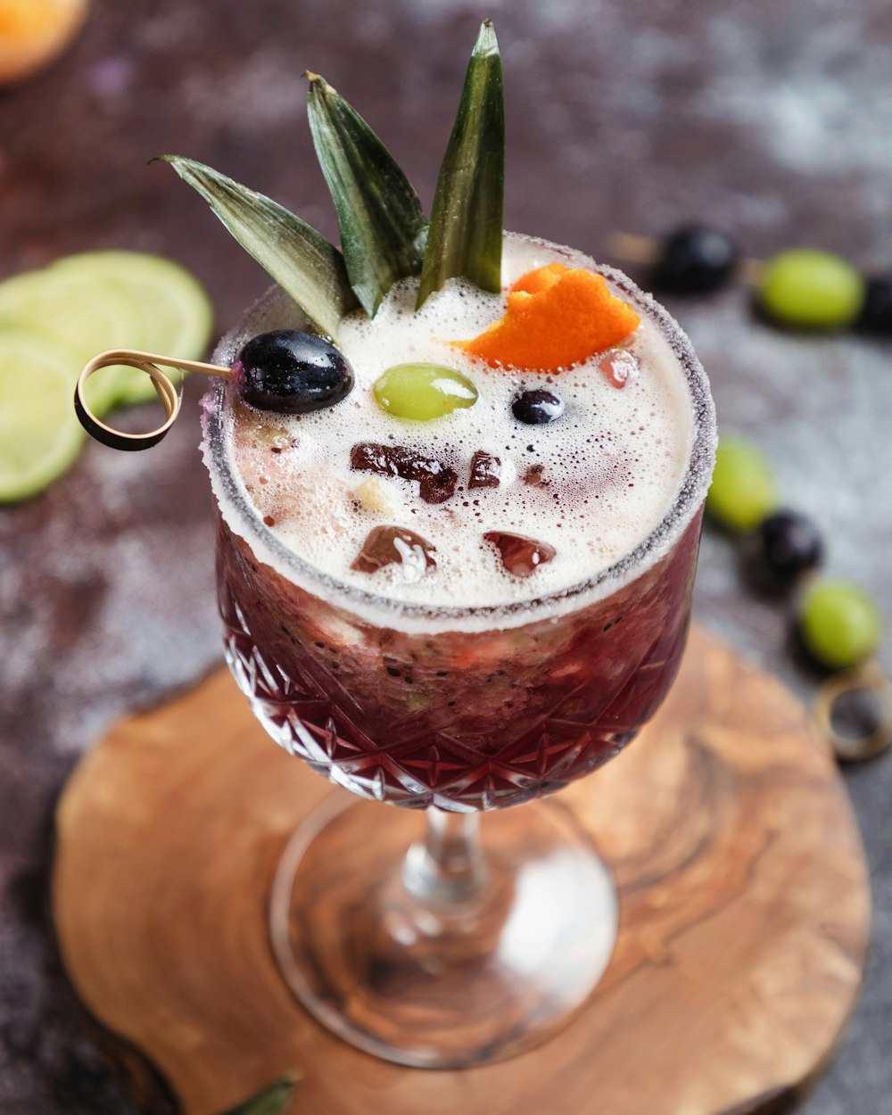 a glass filled with a drink on top of a wooden table