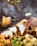 A hand dips a triangular piece of white cheese into a bowl of honey surrounded by various types of cheese, nuts, dried fruits, and grapes. A glass of white wine is visible in the background.
