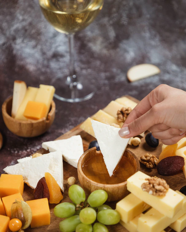a person reaching for a piece of cheese