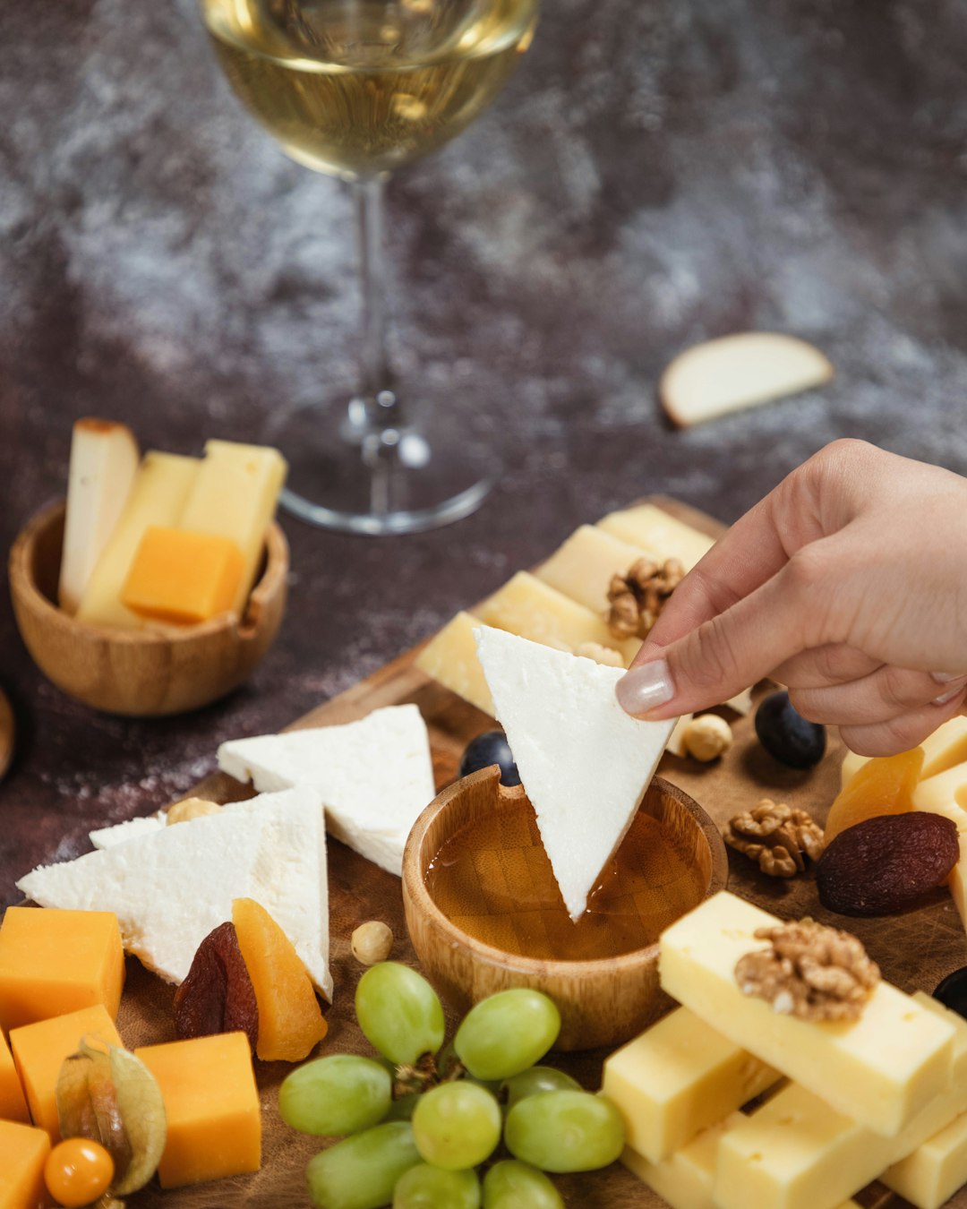 a person reaching for a piece of cheese