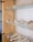 A glass display case is filled with an array of glittering tiaras and crowns, each intricately designed with crystals and pearls. The shelves showcase the delicate craftsmanship of the jewelry pieces, which are neatly arranged with some necklaces and matching accessories.
