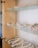 A glass display case is filled with an array of glittering tiaras and crowns, each intricately designed with crystals and pearls. The shelves showcase the delicate craftsmanship of the jewelry pieces, which are neatly arranged with some necklaces and matching accessories.