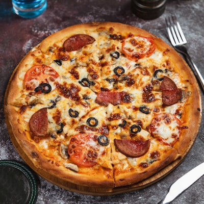 a pizza sitting on top of a wooden cutting board