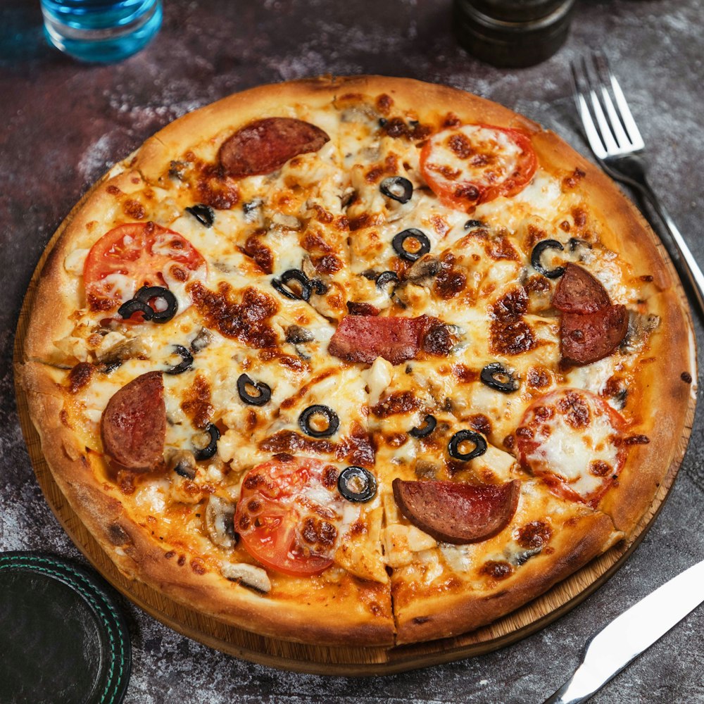 a pizza sitting on top of a wooden cutting board