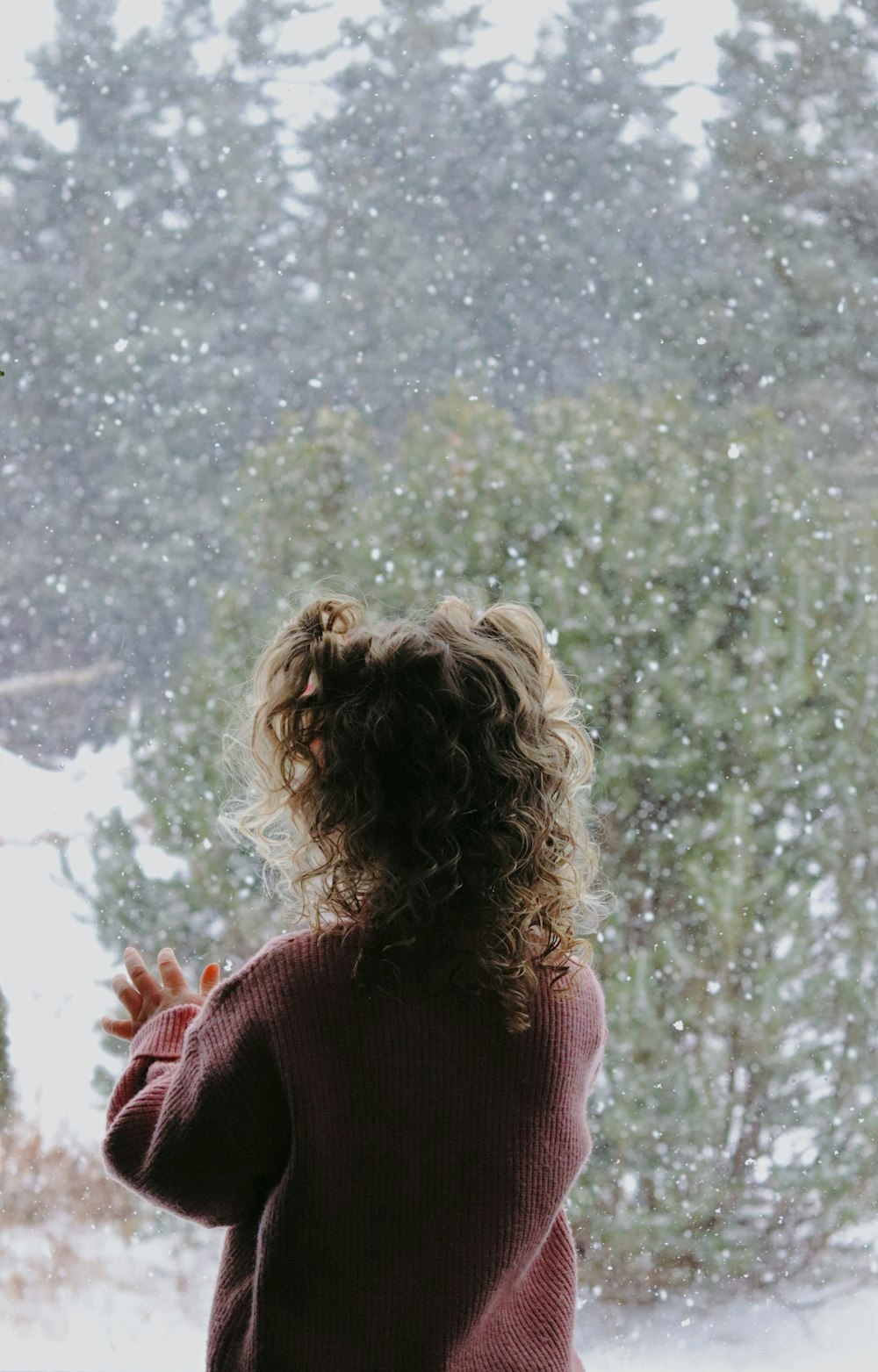 a little girl standing in front of a window