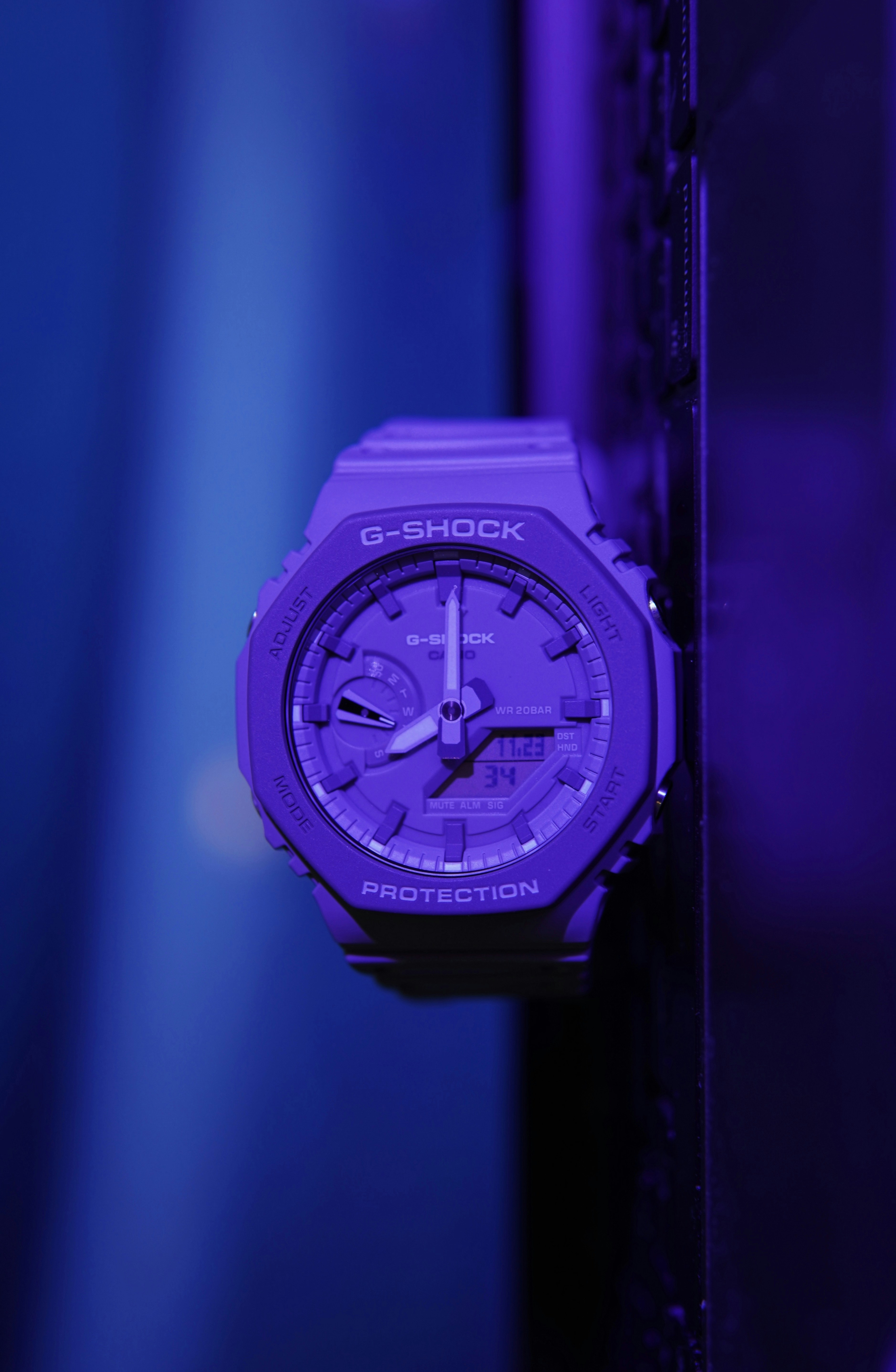 a purple watch hanging on a purple wall