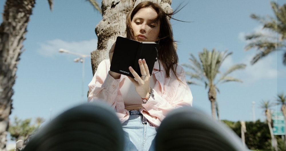 a woman sitting on a bench reading a book