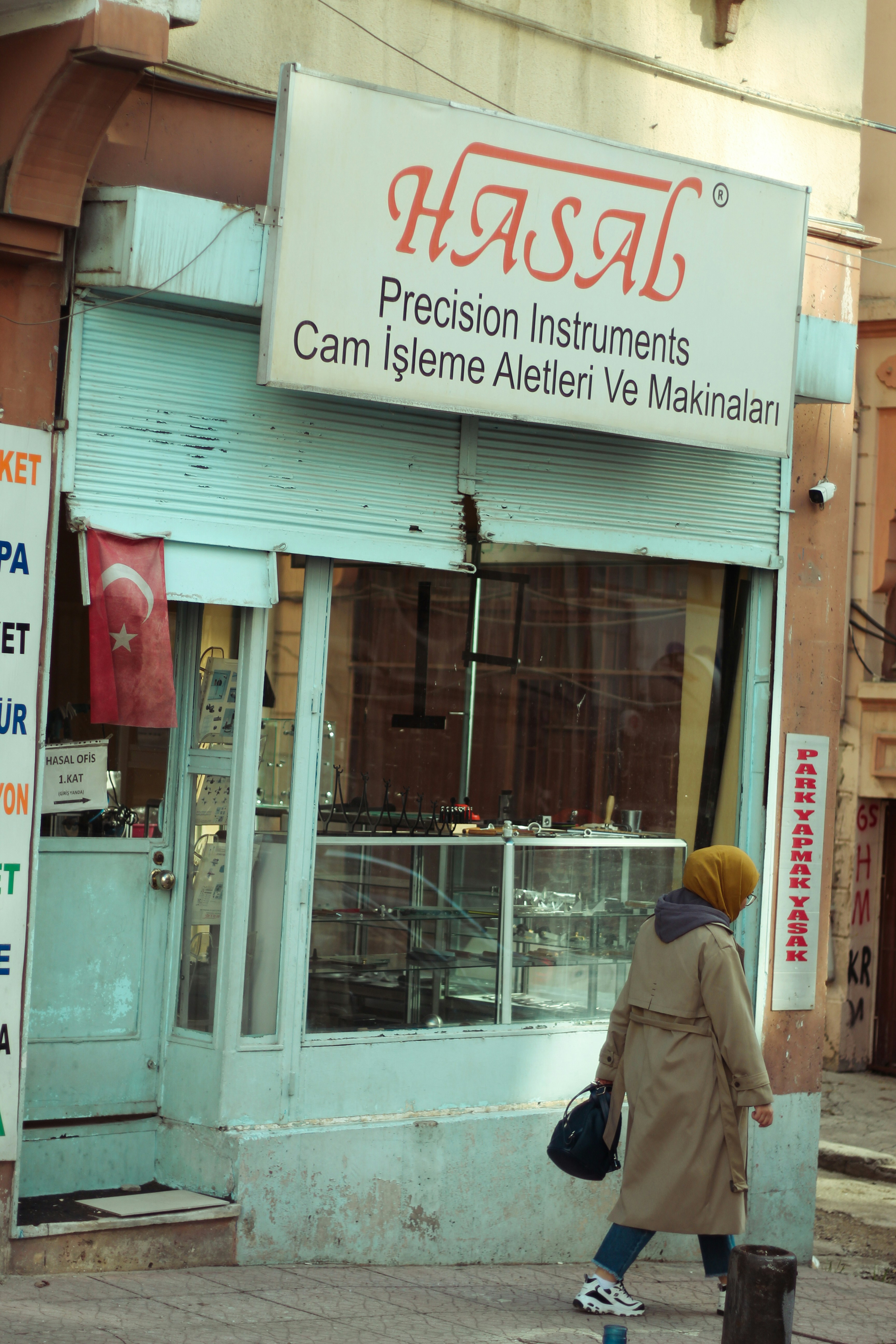 a woman walking down a street past a store
