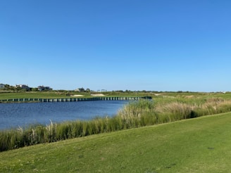 a view of a golf course with a bridge in the distance