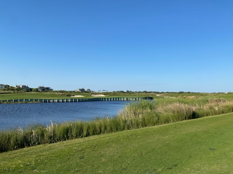 a view of a golf course with a bridge in the distance