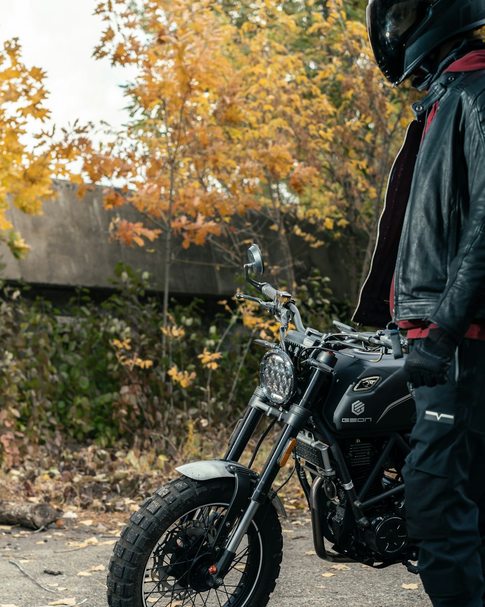 a man standing next to a motorcycle on a road