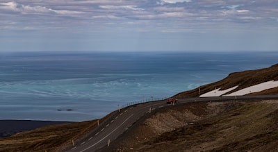 A car influencer filming a dynamic drive through winding coastal roads.