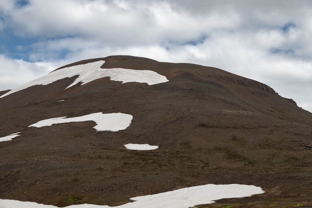 ein schneebedeckter Berg unter einem bewölkten Himmel