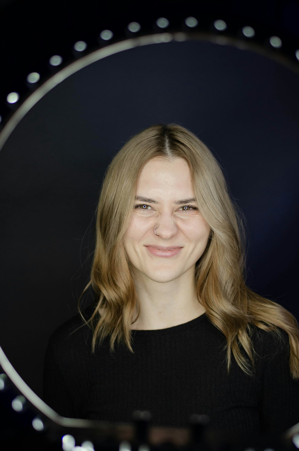 a woman is smiling in front of a mirror