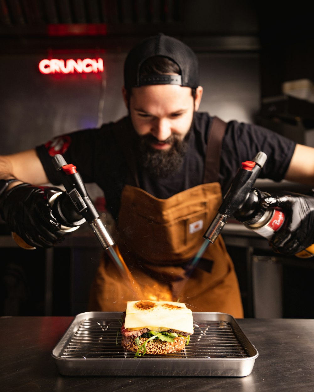 a man in an apron cooking a sandwich on a grill