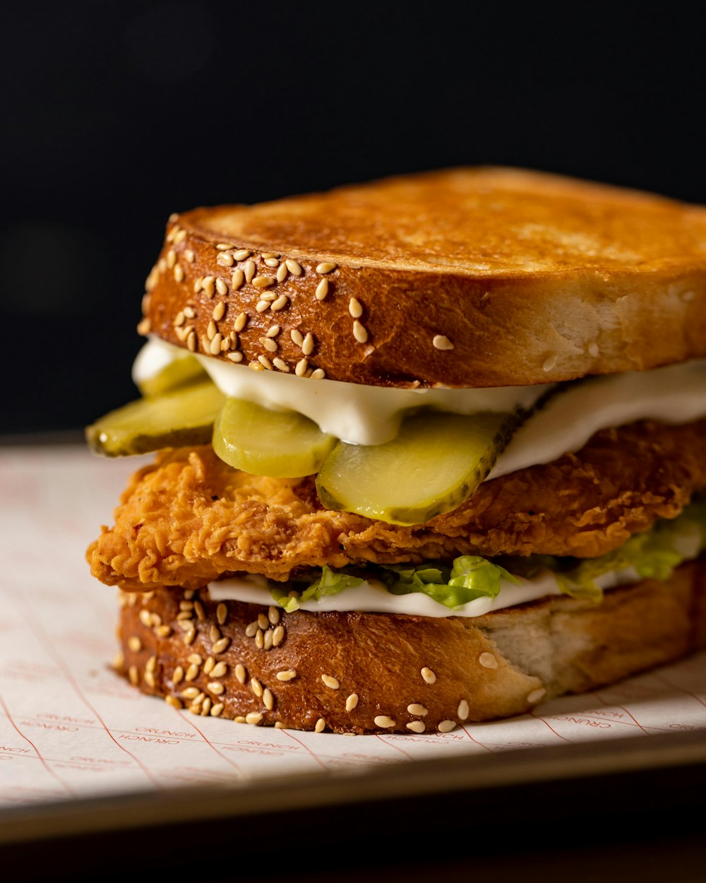 a chicken sandwich with pickles and mayonnaise
