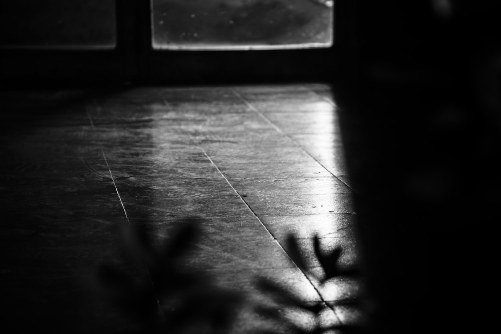 a black and white photo of a floor and a window