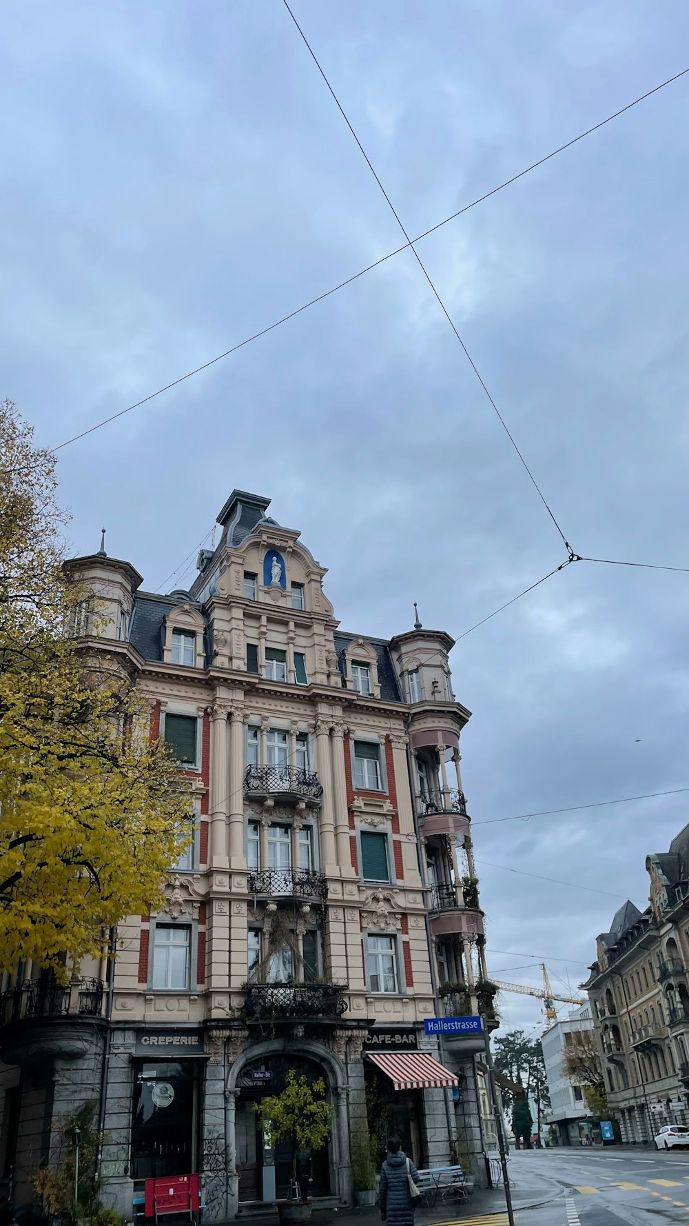 Un edificio alto con molte finestre all'angolo di una strada