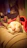 A happy cat resting comfortably on a cozy blanket with soft natural lighting.