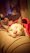 A happy cat resting comfortably on a cozy blanket with soft natural lighting.