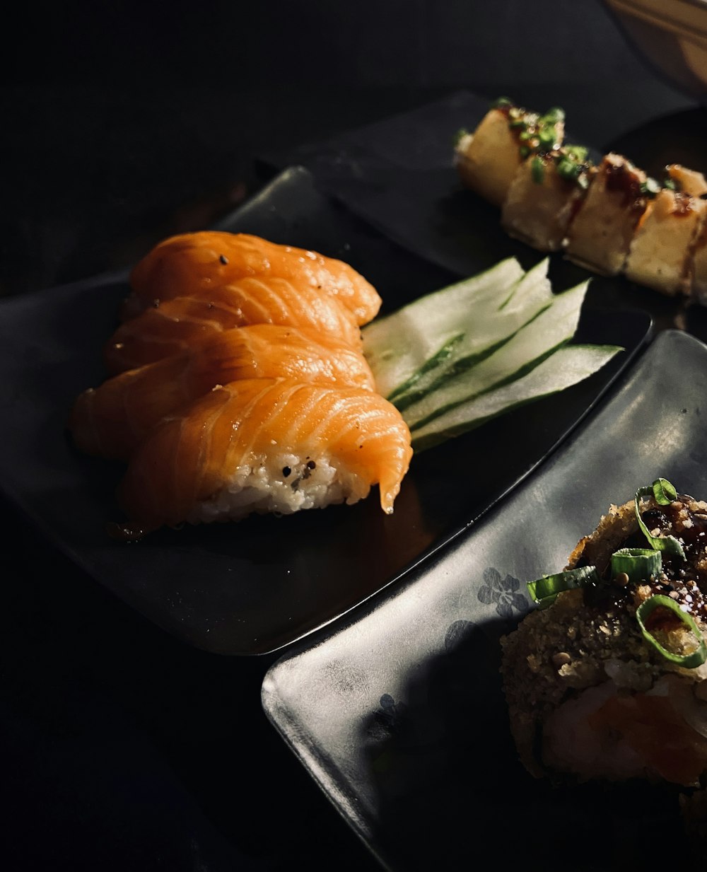 a black plate topped with different types of sushi