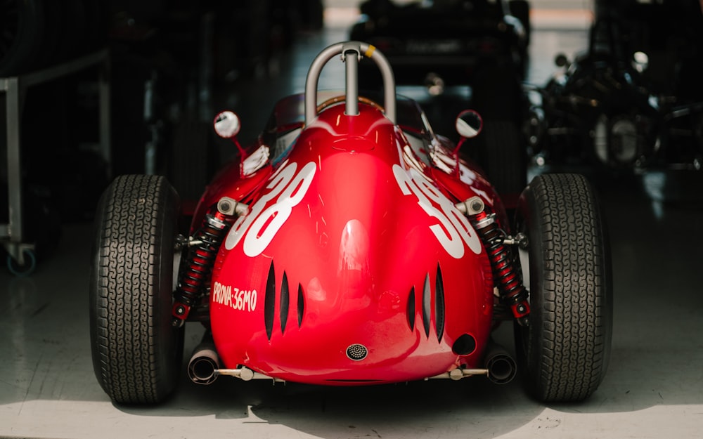 a red race car sitting in a garage