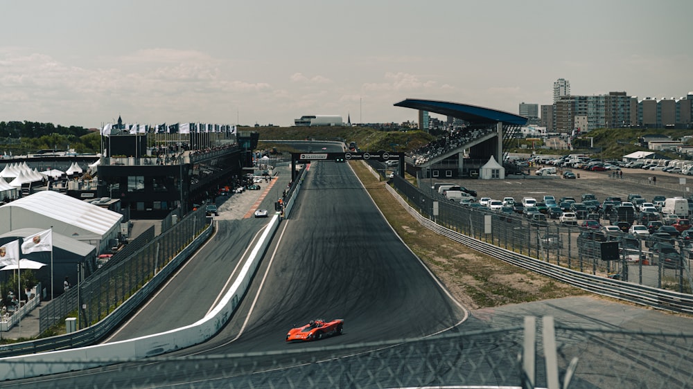 a red race car driving down a race track