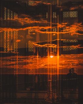 the sun is setting over the water in the distance