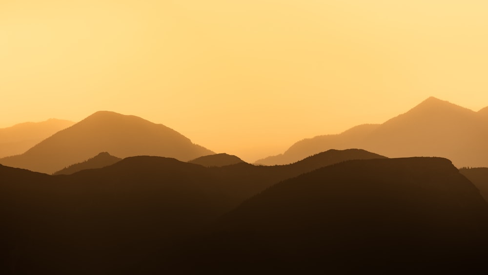 the silhouette of a mountain range at sunset