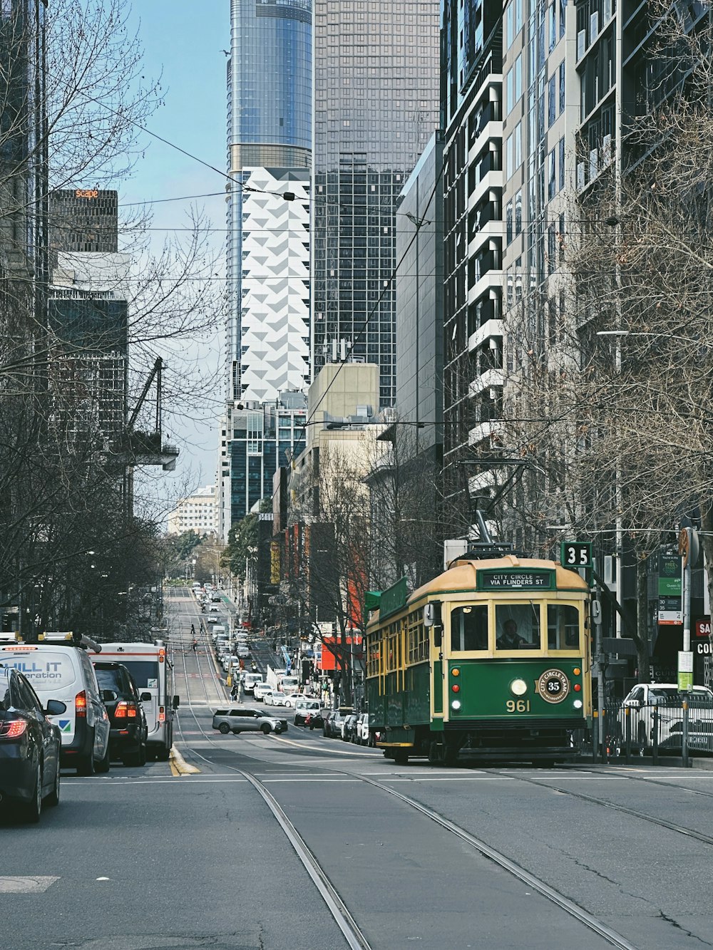a trolley car on a city street with tall buildings