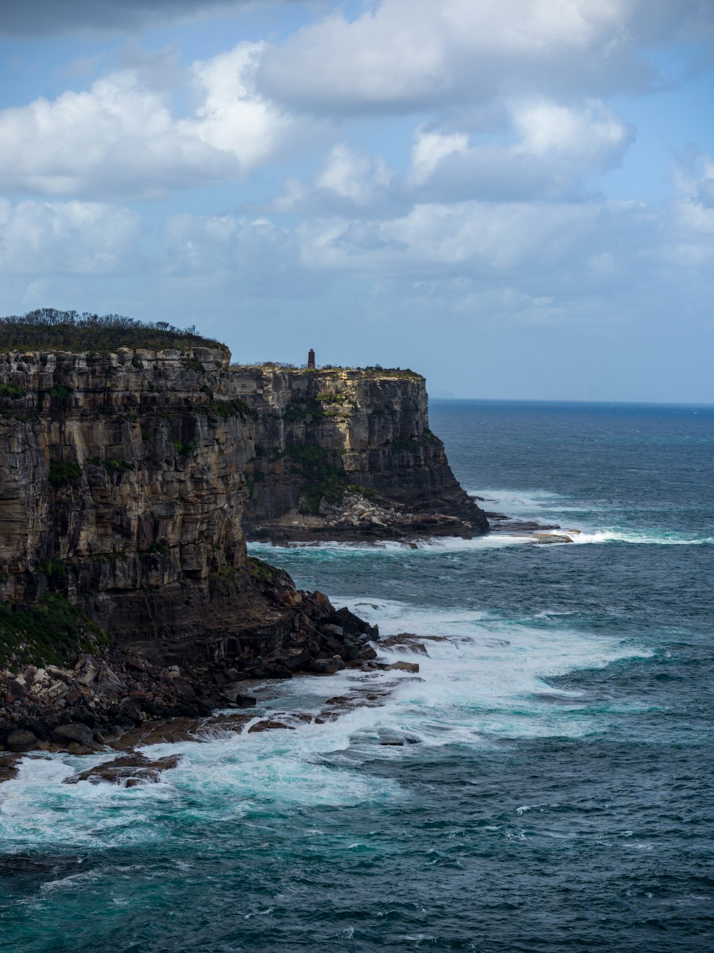 a large body of water next to a rocky cliff