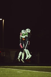 two football players hugging each other on a field