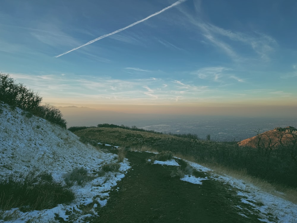 a snow covered path leading to the top of a hill