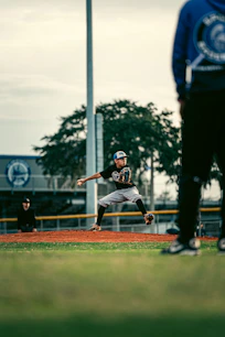 a baseball player pitching a ball on top of a field