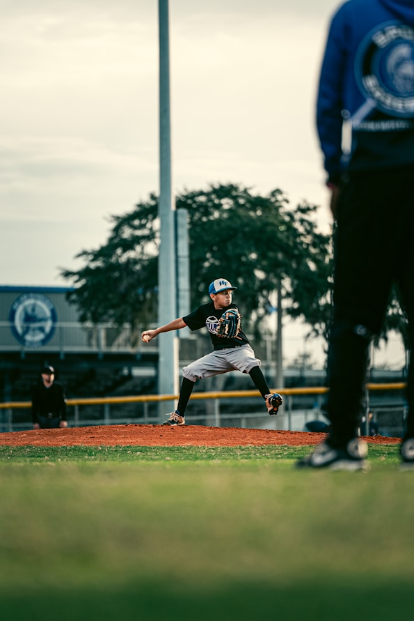 a baseball player pitching a ball on top of a field