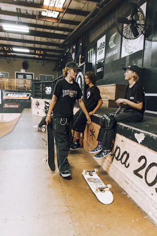 Group of skaters hanging out, all wearing gear featuring Kronos Bearings branding.