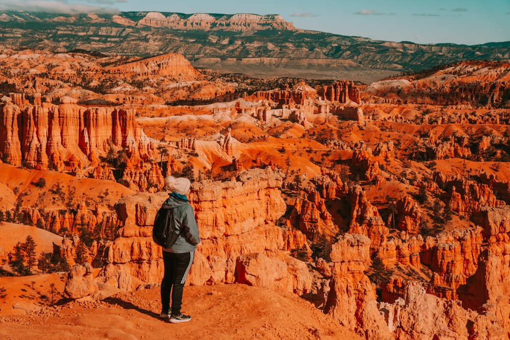 a man standing on top of a cliff in the desert