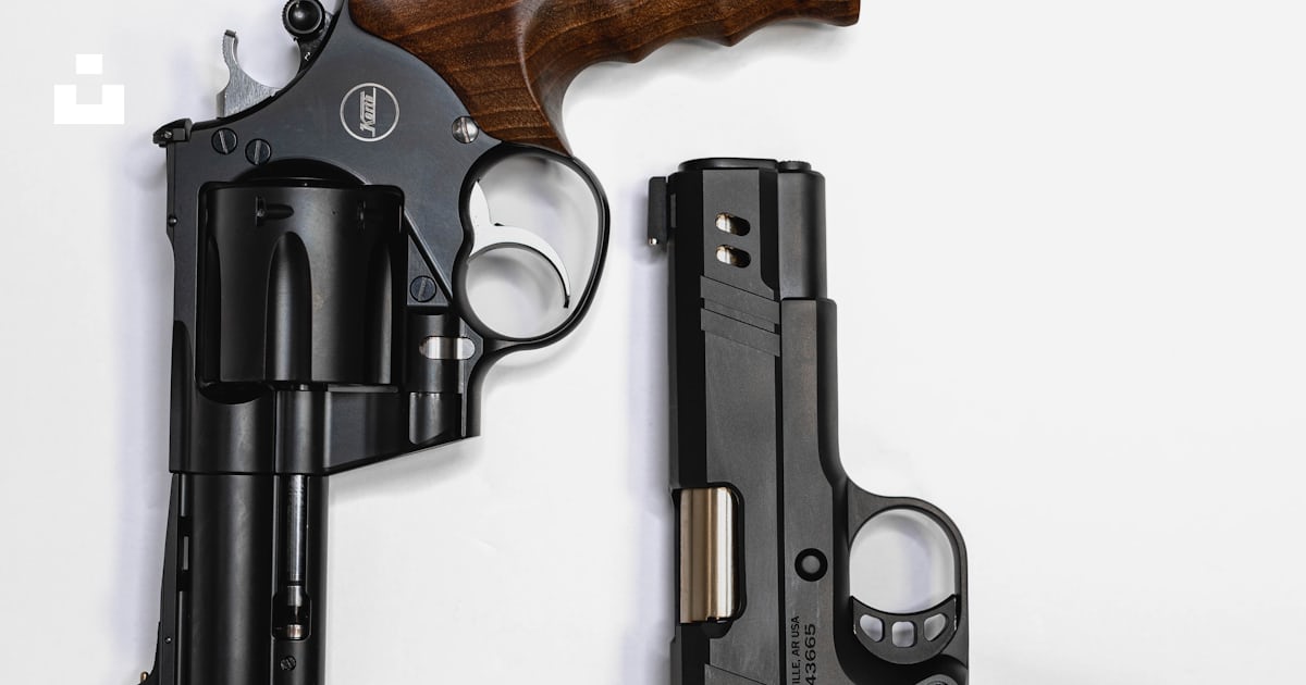 A couple of guns sitting next to each other photo – Free Handgun Image ...