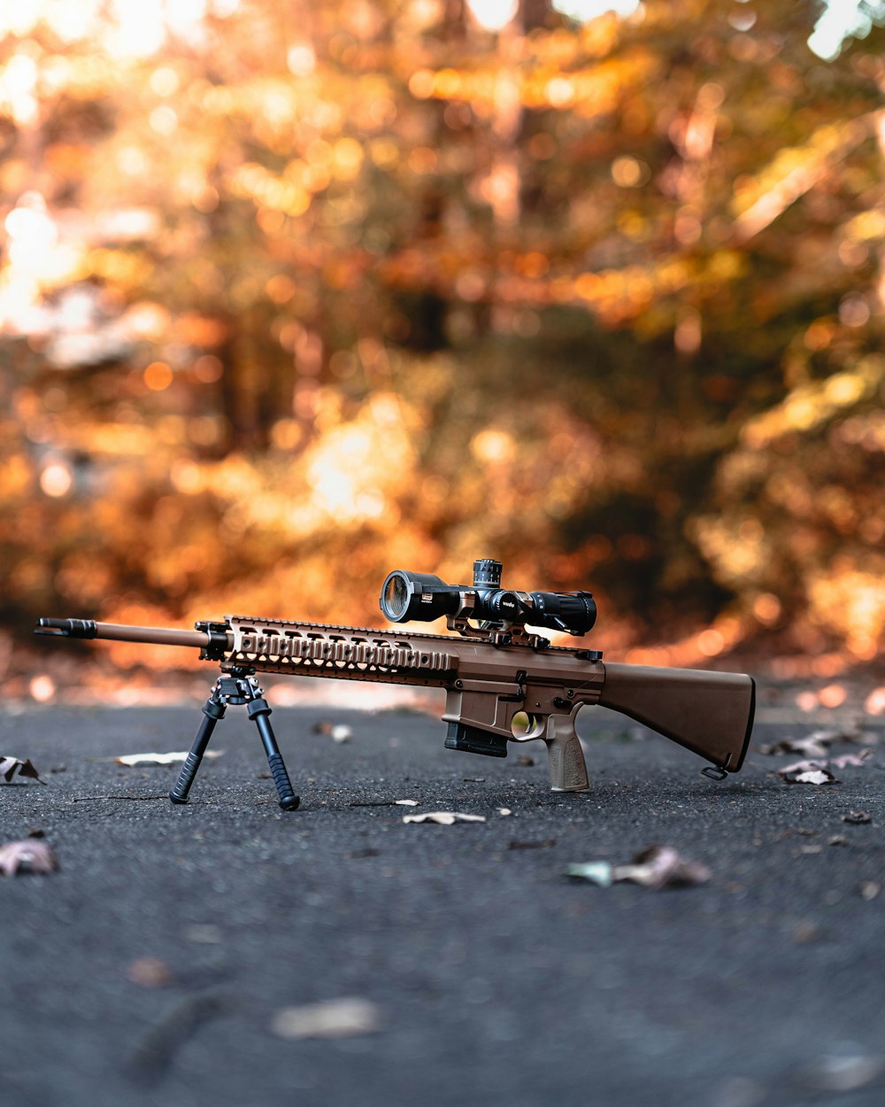 a rifle on the ground with a scope on it
