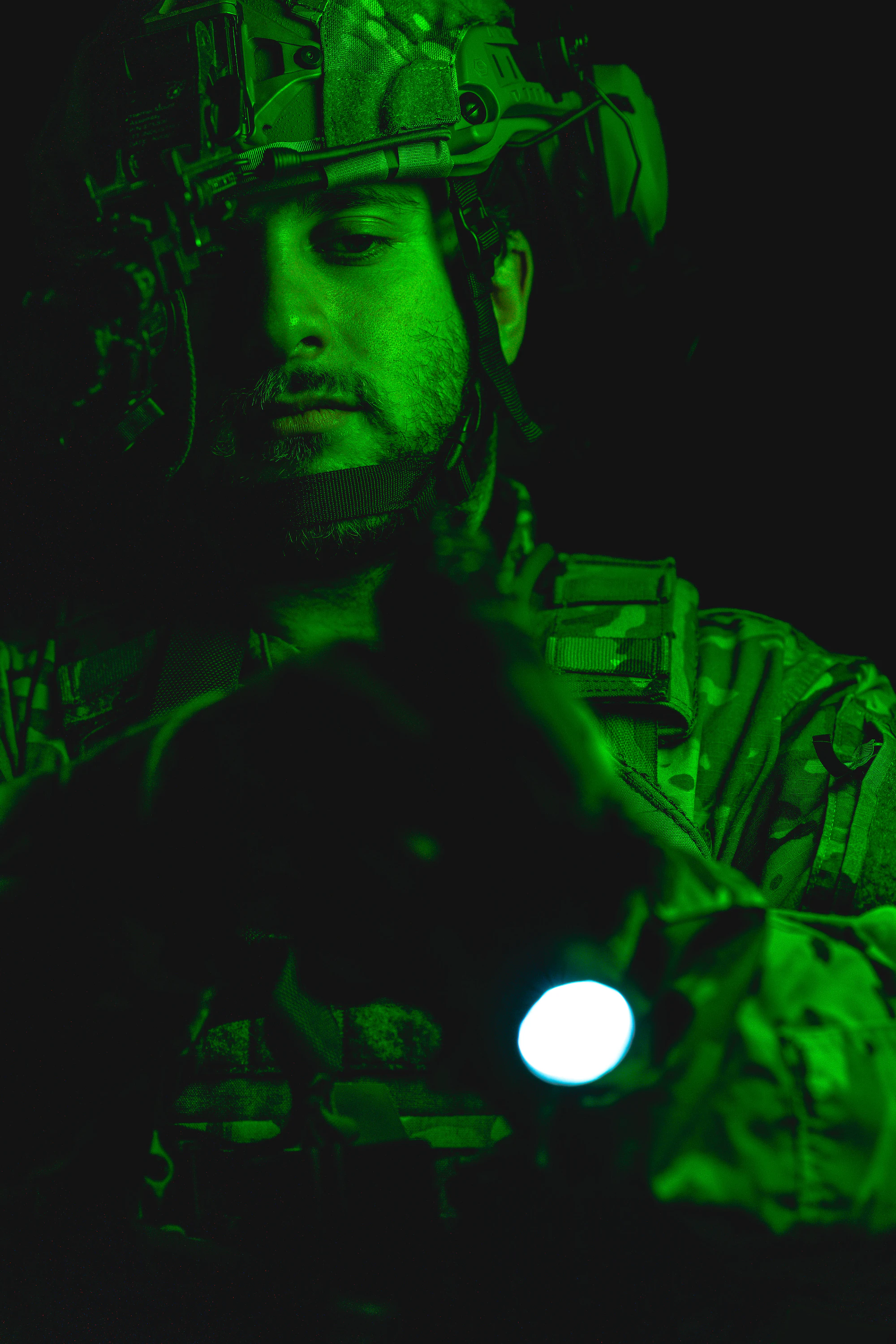 A ground operator at night seen through night vision.